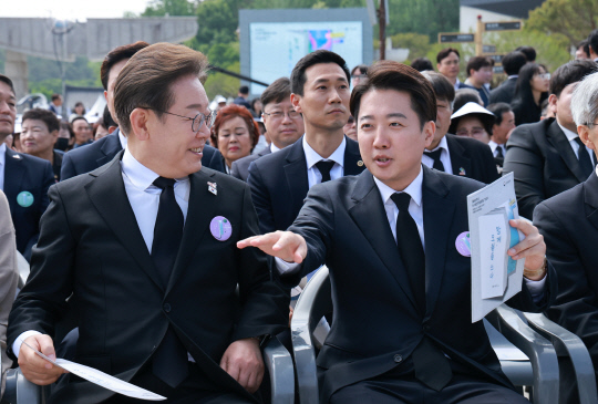 이재명 더불어민주당 대선후보(왼쪽)와 이준석 개혁신당 대선 후보(오른쪽)가 18일 광주광역시 북구 국립 5·18민주묘지에서 열린 5·18민주화운동 45주년 기념식에서 대화하고 있다. 연합뉴스.
